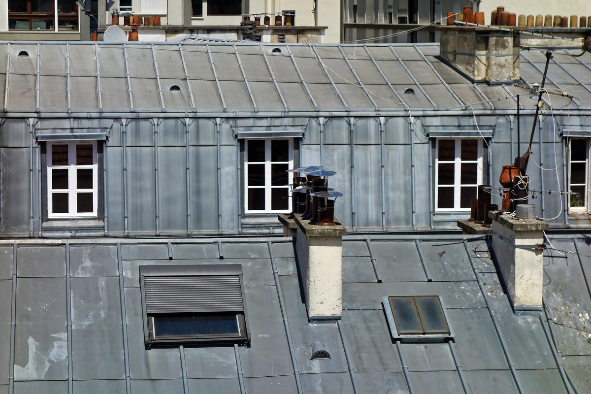 Surface d'un toit parisien en zinc à tasseaux : joints, tabatières et souches de cheminée